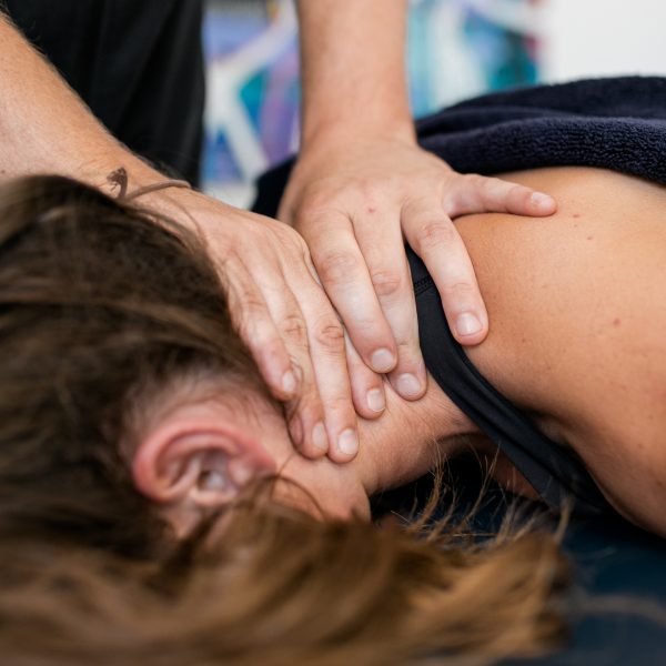 Physiotherapist providing hands-on neck treatment at Premier Sports and Spinal Medicine